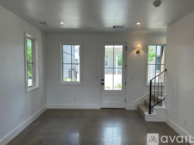 A spacious room with a staircase leading to the second floor.