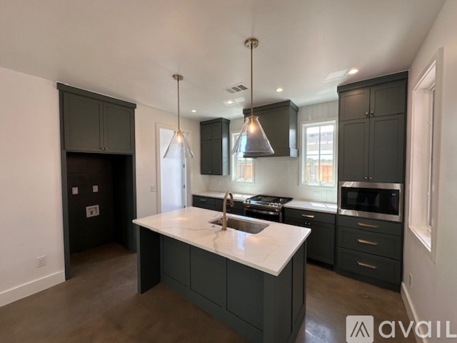A kitchen with a white countertop and dark cabinets.