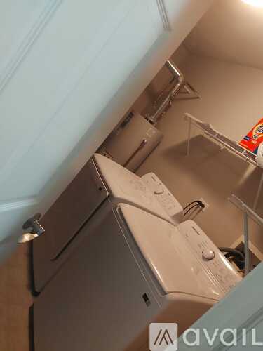 A white dishwasher is in a kitchen under a counter.