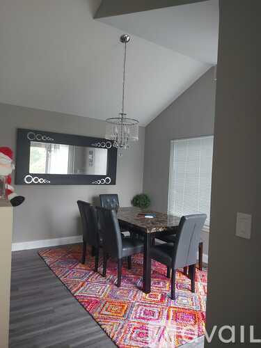 A dining room with a table and chairs.