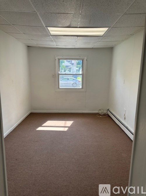 A room with a window and a car visible outside.