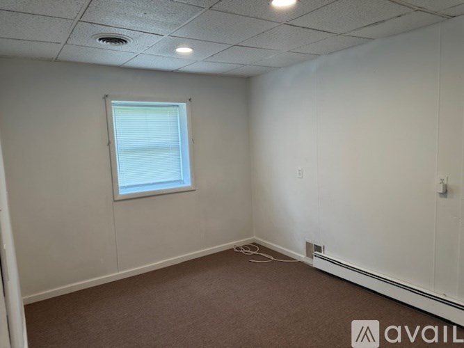 A room with a window and carpeted floor.
