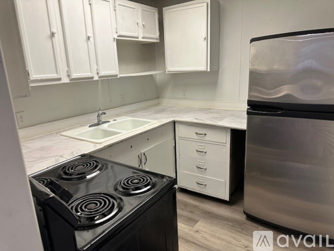 A kitchen with white cabinets and a black stove top oven.