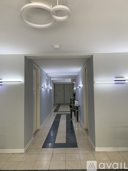 A long hallway with a blue and white striped rug on the floor.
