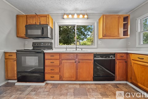 A kitchen with wooden cabinets and black appliances.