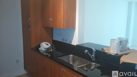 A kitchen with wooden cabinets and a black countertop.