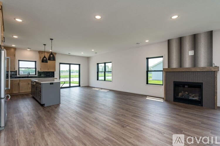A modern kitchen with a refrigerator, a stove, and a fireplace.