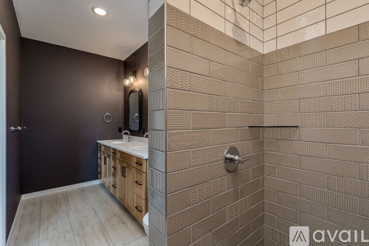 A bathroom with a tiled shower and a sink.