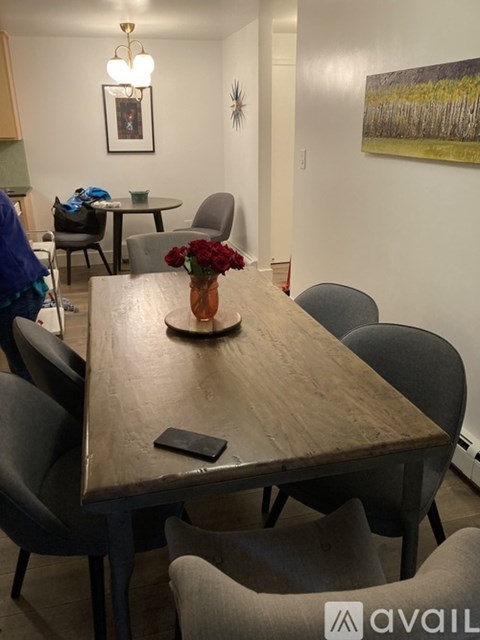 A long wooden table with a vase of flowers and a book on it.