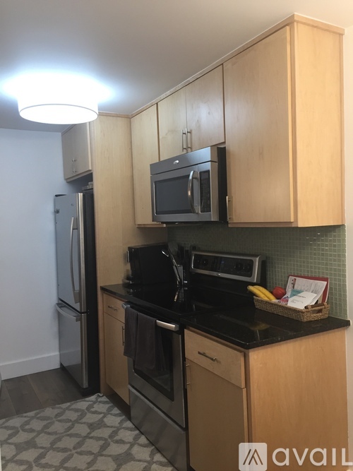 A kitchen with wooden cabinets and black countertops.