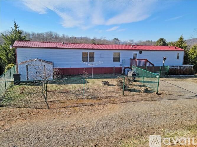 A red and white building with a green fence in front.