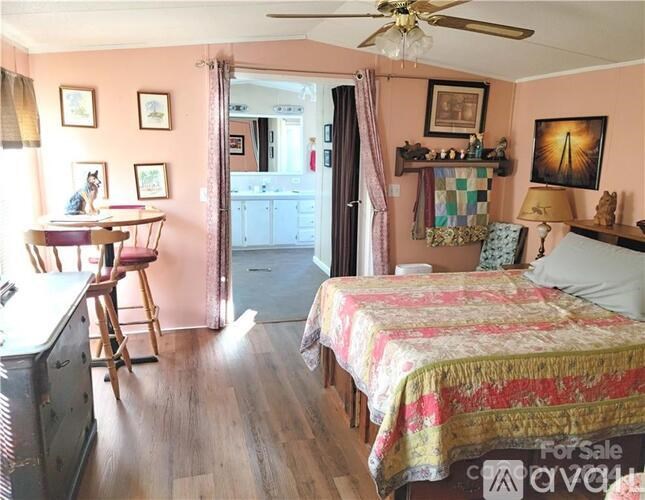 A bedroom with a bed, a desk, and a chair.