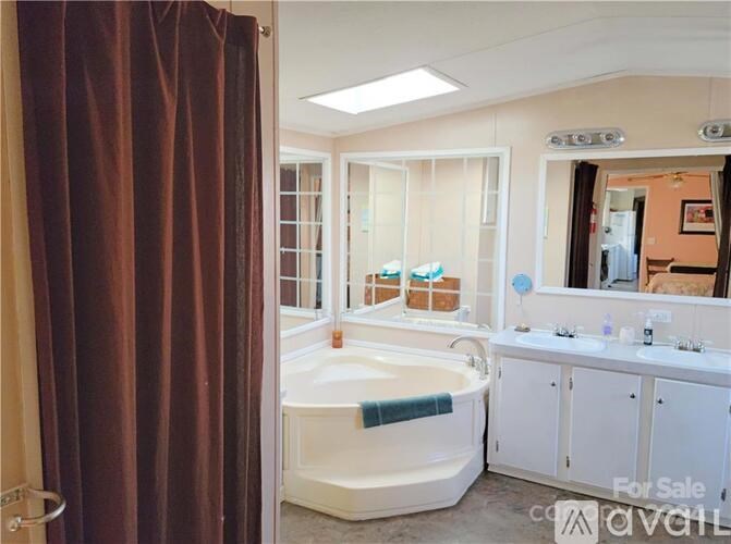 A bathroom with a bathtub, sink, and mirror.