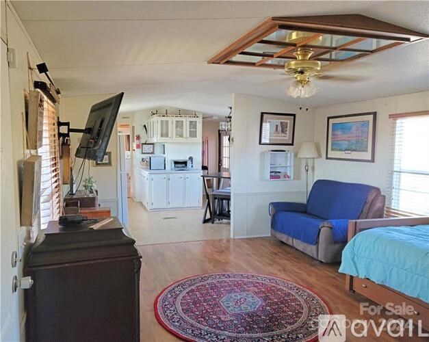 A living room with a couch, a television, and a rug.
