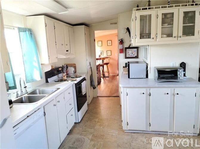 A kitchen with white cabinets and appliances.