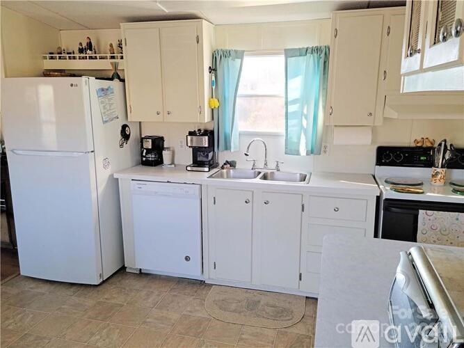 A kitchen with white appliances and cabinets.
