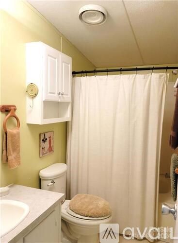 A bathroom with a toilet, sink, and shower.