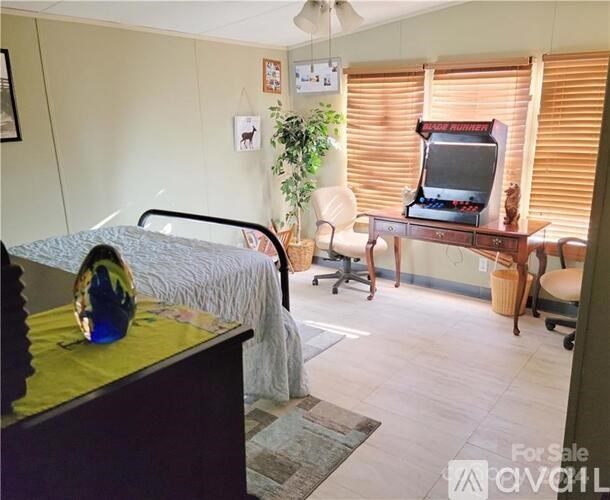 A bedroom with a bed, chair, and television.
