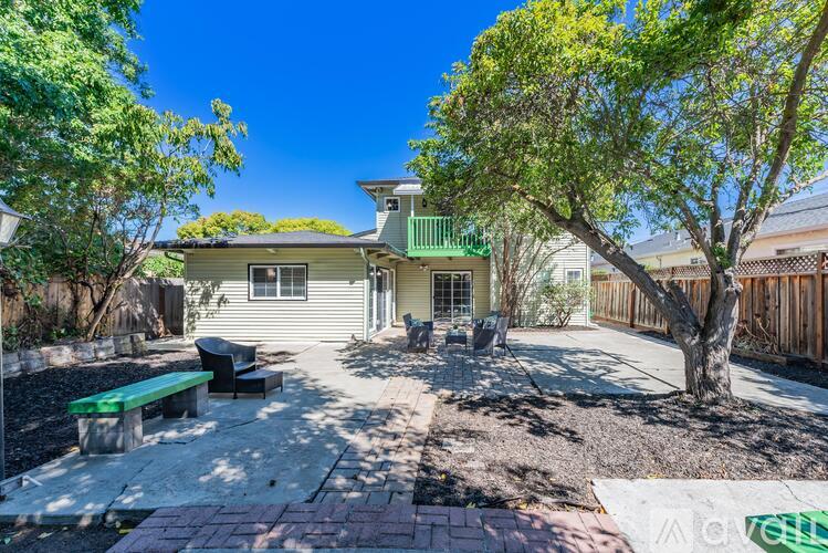 A house with a green roof and a tree in front.