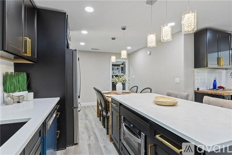 A modern kitchen with a black oven and a black induction cooktop with pink burner controls.