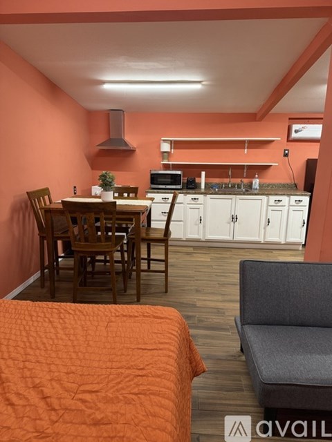 A kitchen with orange walls and wooden furniture.