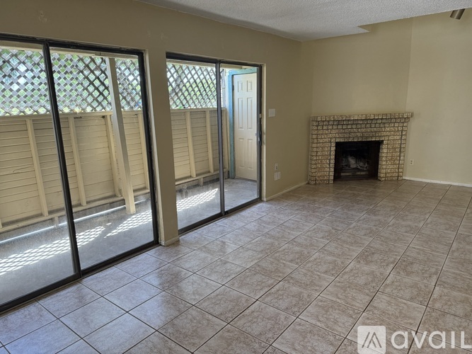 A room with a fireplace and sliding glass doors.
