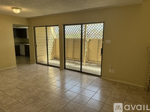 A room with tiled flooring and sliding glass doors.