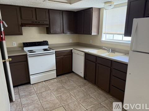 A kitchen with brown cabinets and a white stove.
