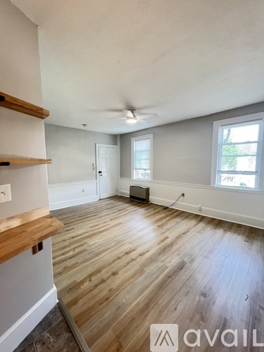 A room with wooden flooring and a ceiling fan.