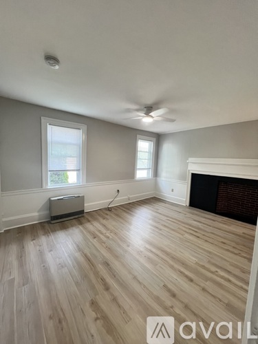 A room with wooden floors and a fireplace.