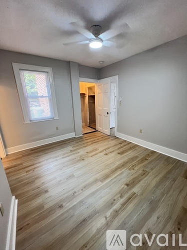 A room with wooden flooring and a ceiling fan.