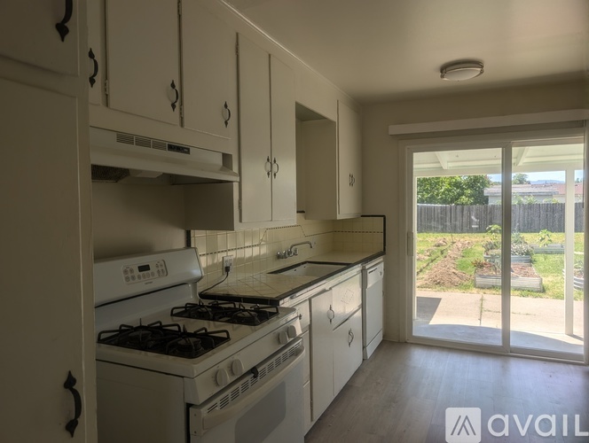 A kitchen with white appliances and cabinets is available for rent.