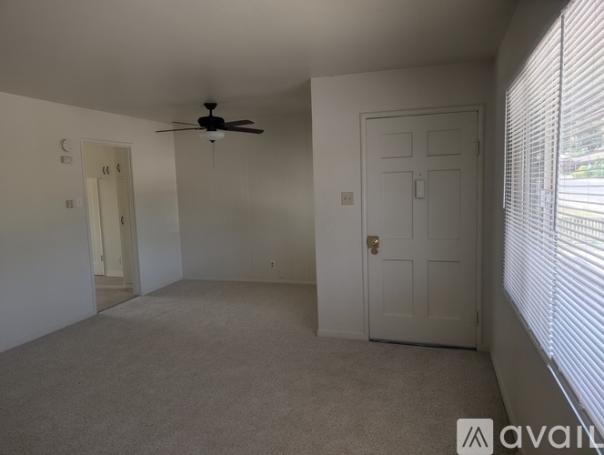 A room with a ceiling fan and two doors.