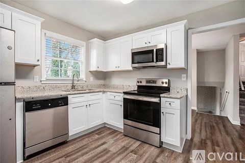 A kitchen with white cabinets and stainless steel appliances.