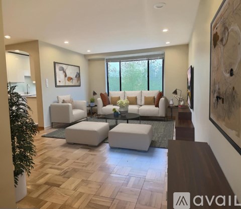 A living room with a large couch, a coffee table, and a painting on the wall.