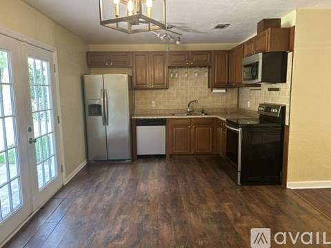 A kitchen with wooden floors and a black stove top oven.