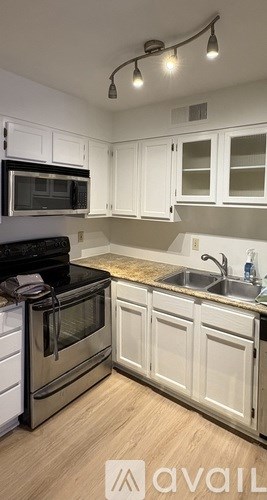 A kitchen with white cabinets and a black stove top oven.