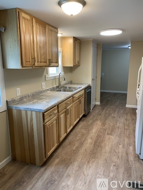 A kitchen with wooden cabinets and a marble countertop.