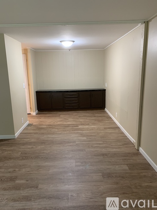 A room with wooden flooring and a cabinet in the corner.