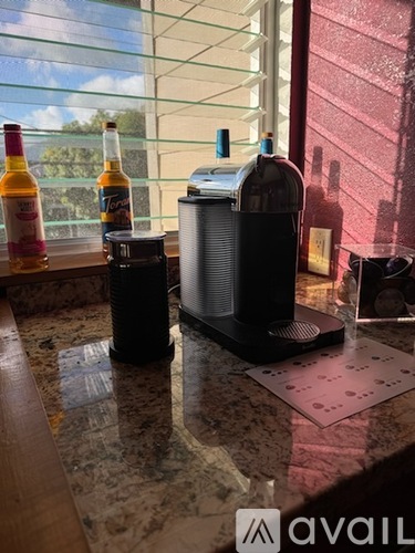 A bottle of Tequila is on a counter next to a speaker.