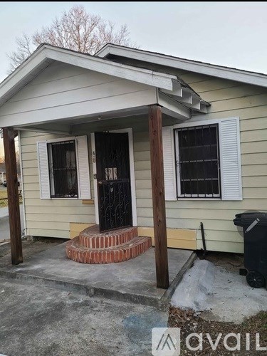 A small house with a black door and a brick step leading to the entrance.