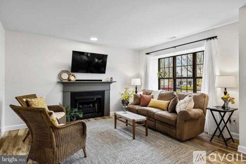 A living room with a fireplace and a television on the wall.