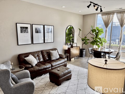A living room with a brown leather couch and a round table.