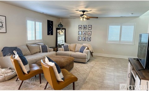 A living room with a brown leather couch and two matching chairs.