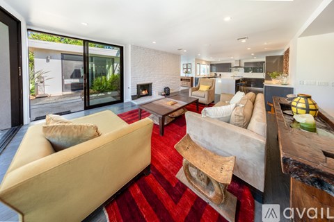 A living room with a red carpet and a fireplace.