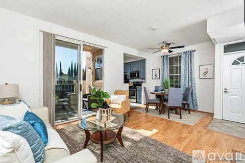 A living room with a glass door leading to a balcony.