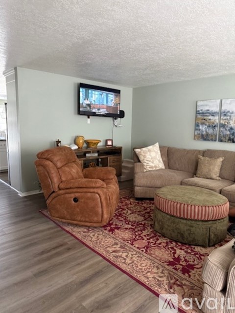 A living room with a brown chair and ottoman.
