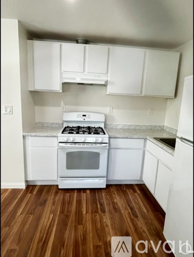 A white stove and oven in a kitchen with wooden floors.
