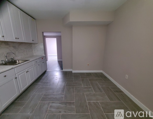 A kitchen with white cabinets and a tiled floor.