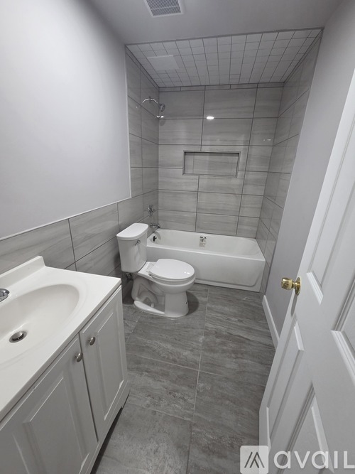 A spacious room with a tiled floor and a ceiling fan.